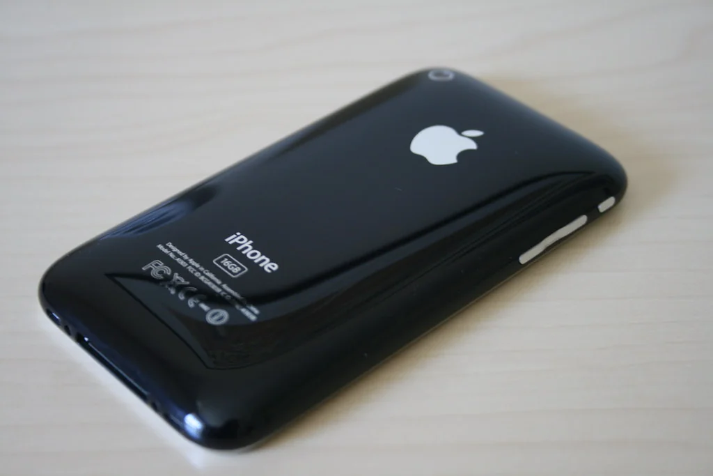 Black iPhone lying face down on a wooden desk