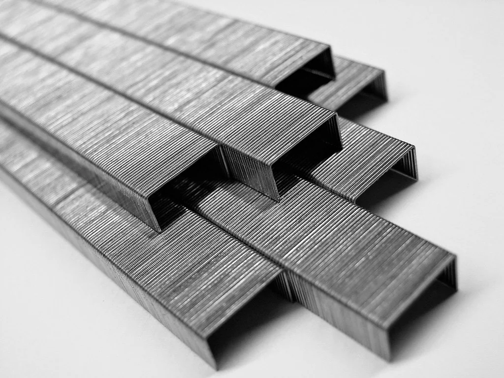 Strips of metal staples lying on a white surface