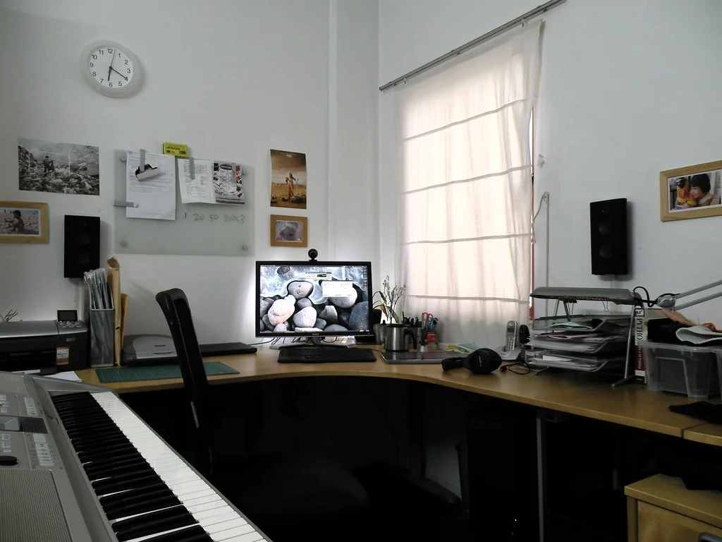 Home office desk with a monitor, keyboard and printer
